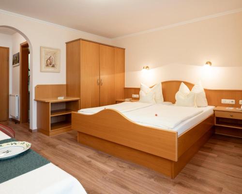 a bedroom with a large bed with white sheets at App.-Haus zur Europa-Therme in Bad Füssing