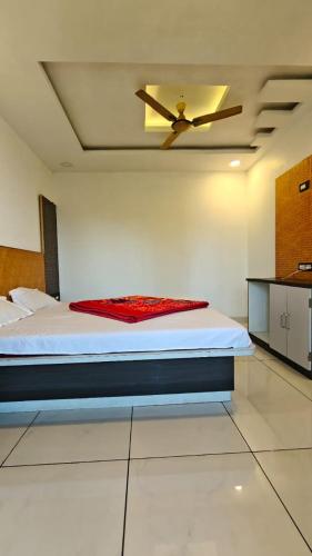 a bedroom with a bed with a ceiling fan at Hotel Prathamesh in Panchgani