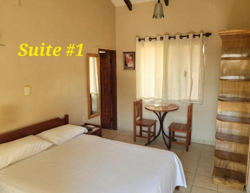 ein Schlafzimmer mit einem Bett und einem Tisch und Stühlen in der Unterkunft Hostal Landivar - A media cuadra de la plaza in Buena Vista