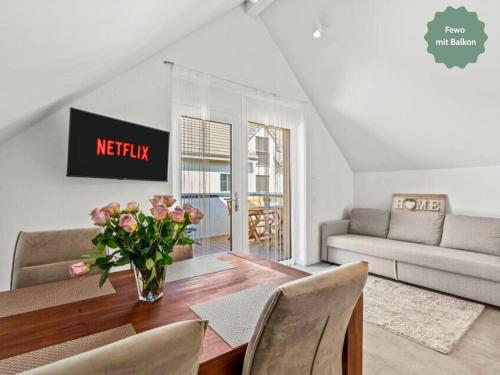 un soggiorno con un tavolo con un vaso di fiori di Ferienhausträume-Bodensee Bergstrassen Apartments a Kreuzlingen