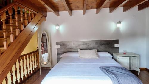 ein Schlafzimmer mit großem Bett und Treppe in der Unterkunft Casa vacacional El Rincón de Soto in Soto de Cangas