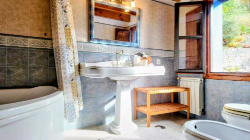 ein Badezimmer mit Waschbecken und Toilette in der Unterkunft Casa vacacional El Rincón de Soto in Soto de Cangas
