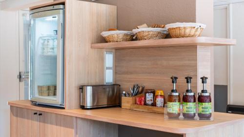 a counter with a microwave and some bottles on it at Premiere Classe Bourges in Bourges