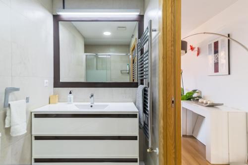 ein Badezimmer mit Waschbecken und Spiegel in der Unterkunft Apto playa Alojamientos Marte in Suances