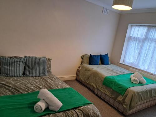 a bedroom with two beds with towels on them at Cosy 2 Bedroom Luxury House in Wednesbury