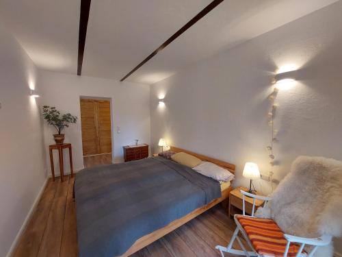 a bedroom with a bed and a chair and lights at Domus Campus Latus - Ferienwohnungen Breitenfeld in Gumtow