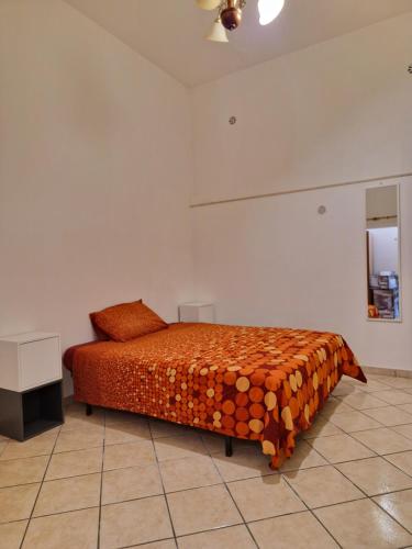 - une chambre avec un lit et une couette en orange dans l'établissement Casa butterfly Sacrofano, à Sacrofano
