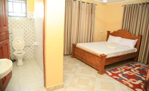 a bedroom with a bed and a bathroom with a toilet at The Hidden Paradise in Mombasa
