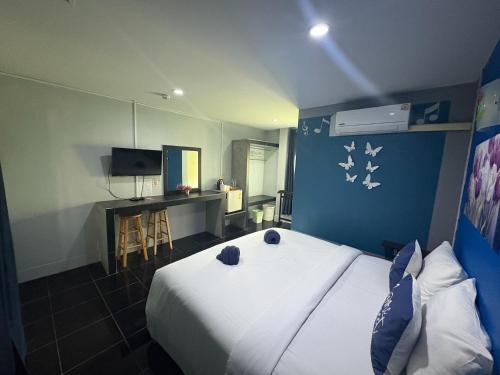 a bedroom with a white bed and a blue wall at Krabi Nemo House in Ao Nang Beach
