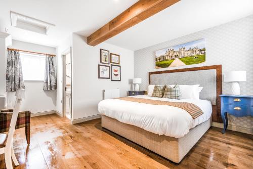 Un dormitorio con una cama grande y suelo de madera. en The Walhampton Arms, en Lymington
