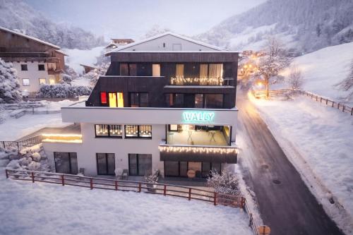 a building with a sign on it in the snow at Wally Berg-Appartements in Zams