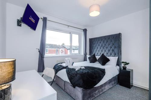 a bedroom with a bed with a large window at Middleton 4 Bed Free Parking Long stays in Middleton