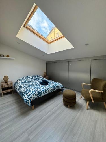 ein Schlafzimmer mit einem Bett und einem Dachfenster in der Unterkunft Chez Gomera in Verdun-sur-Meuse