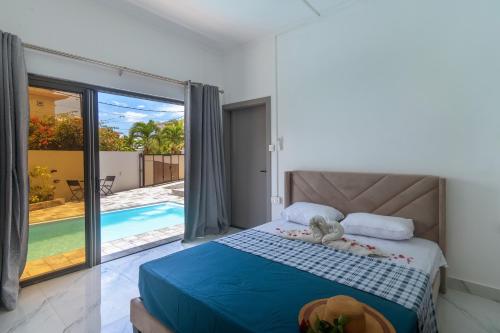 a bedroom with a bed with a view of a pool at Peaceful Villa by Oceanaxe Holidays in Grand Baie