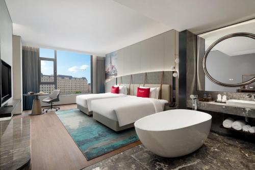 Postel nebo postele na pokoji v ubytování Ramada by Wyndham Qingdao Jiaodong International Airport