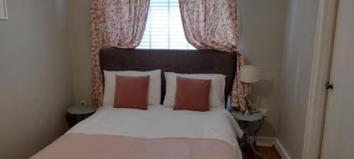a bedroom with a bed with pillows and a window at 2 Courtyard Mews in Penzance