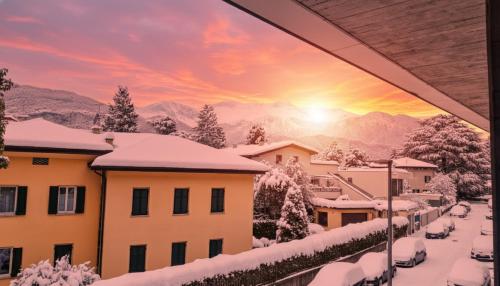 a winter sunrise seen from a balcony with snow covered buildings at -Parcheggio Privato-Riscaldamento Pavimento-WiFi- zona OSPEDALE-CENTRO "COZY PANoRAMA" in Trento