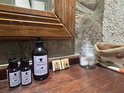 three bottles of essential oils sitting on a wooden table at suites en la montaña con propuesta de viñedo in La Cumbre