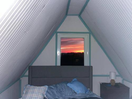 a bed in a room with a window in a attic at Doa Blanca Cabin Mountain View in Utuado