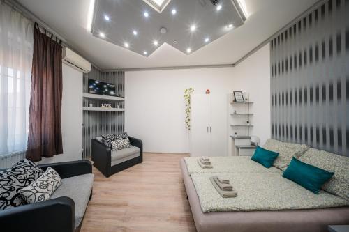 ein Wohnzimmer mit einer Couch und einem Sessel in der Unterkunft Széchenyi Apartman Miskolc belvárosban in Miskolc