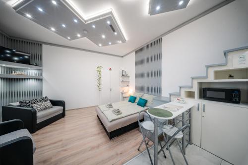ein Wohnzimmer mit einem Bett, einem Tisch und einem Sofa in der Unterkunft Széchenyi Apartman Miskolc belvárosban in Miskolc