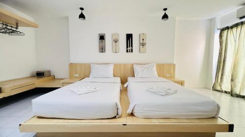 two beds sitting next to each other in a room at Urban Patong Residence in Patong Beach
