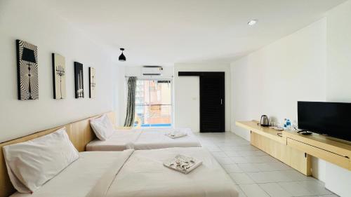 a living room with two beds and a flat screen tv at Urban Patong Residence in Patong Beach