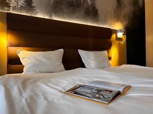 Hotel Orpheus - Casino and SPA في بامبوروفو: كتاب على سرير وفيه مجله عليه