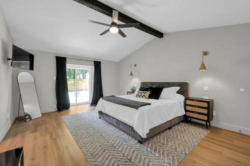 une chambre blanche avec un lit et un ventilateur de plafond dans l'établissement Fire Pit Grill Hammock King Bed, à Spring