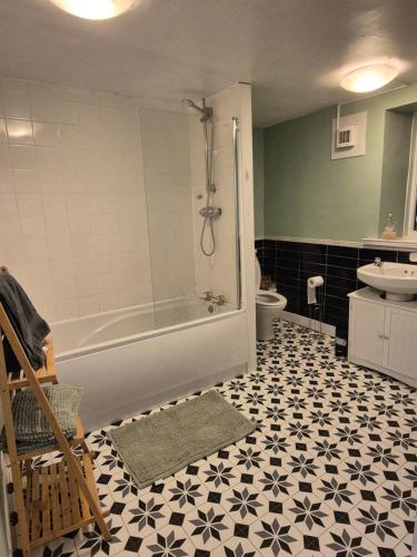a bathroom with a tub and a toilet and a sink at Fox Haven in Bicester