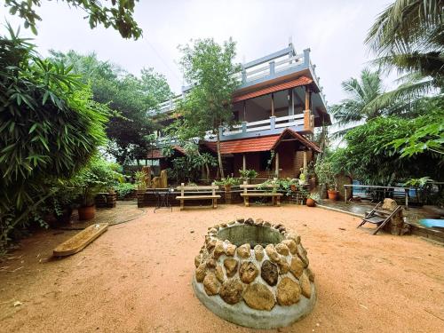 a house with a pile of logs in front of it at Greens Heritage Resort with Swimming Pool in Auroville