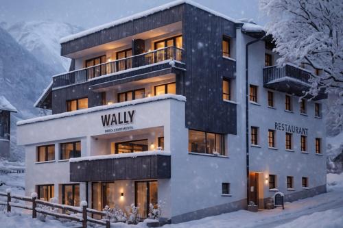 a building with a sign on it in the snow at Wally Berg-Appartements in Zams