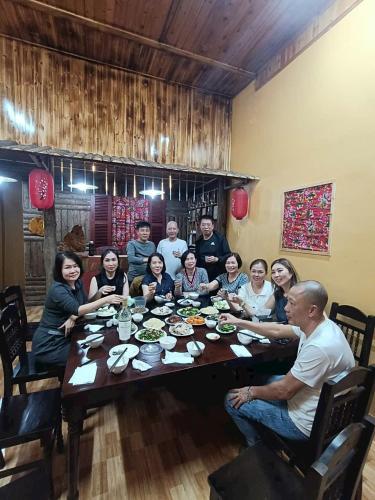 Un grupo de personas sentadas alrededor de una mesa comiendo en Moc's house bắc hà 2, en Bắc Hà