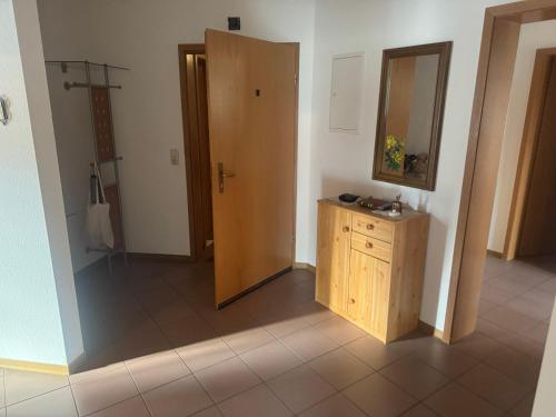 a bathroom with a wooden cabinet and a mirror at LandgasthofOrleshausen in Büdingen