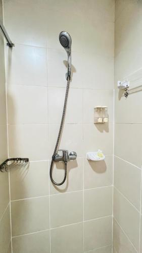 a shower with a shower head in a bathroom at Urban Patong Residence in Patong Beach