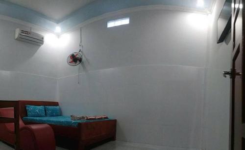 a room with a blue couch and a wall at Nhà nghỉ Đông Phương in Trung An