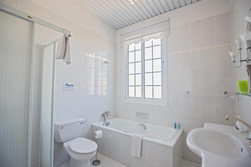 a white bathroom with a toilet and a sink at Papas Family Villa in Paralimni