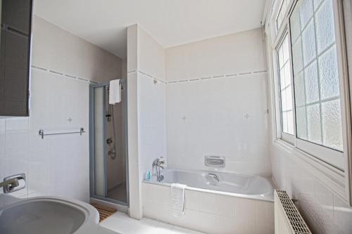 a bathroom with a tub and a sink and a toilet at Papas Family Villa in Paralimni