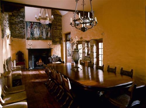 ein Esszimmer mit einem langen Tisch und einem Kamin in der Unterkunft Moongate lodge in Killedmond