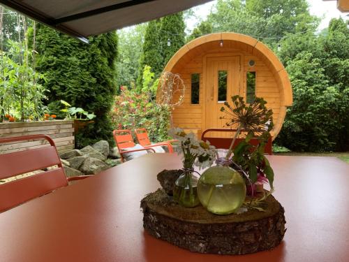 une table avec des fleurs dans des vases sur une souche d'arbre dans l'établissement Villa Aurora, à Labaroche
