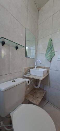 a bathroom with a white toilet and a sink at Casa em Porto de Galinhas - PRIVÊ DAS ONDAS in Porto De Galinhas