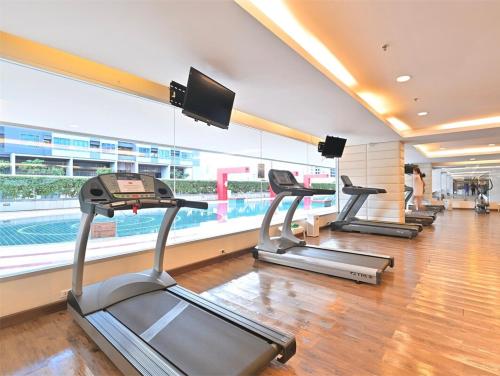 a gym with three treadmills and a swimming pool at Modern Suite near BTS Nana Netflix Sky View in Makkasan