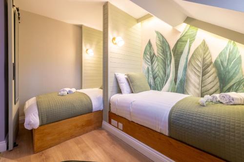 The Secret Garden, Donaghadee - The Hideaway - Guests 7 في Donaghadee: سريرين في غرفة مع لوحة جدارية على الحائط