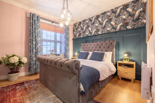 a bedroom with a bed and a wall with birds on it at The Secret Garden, Donaghadee "The Hideaway" in Donaghadee