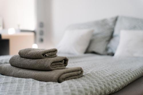 een stapel handdoeken bovenop een bed bij Széchenyi Apartman (III. Panorama) Miskolc belvárosában in Miskolc
