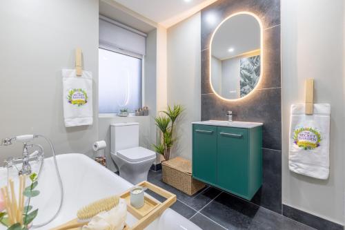 a bathroom with a tub and a sink and a toilet at The Secret Garden, Donaghadee "The Hideaway" in Donaghadee