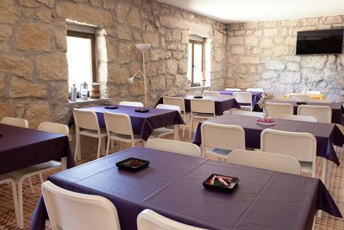 a dining room with blue tables and white chairs at Huerto San Antonio in La Cabrera