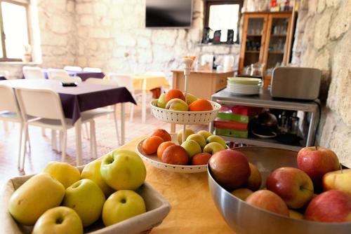 a table topped with bowls of apples and oranges at Huerto San Antonio in La Cabrera