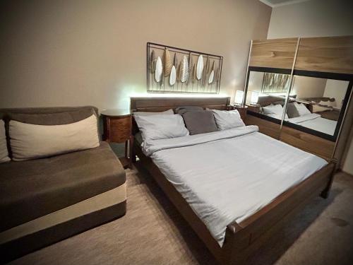 a bedroom with a large bed and a chair at Apartment Centar in Podgorica