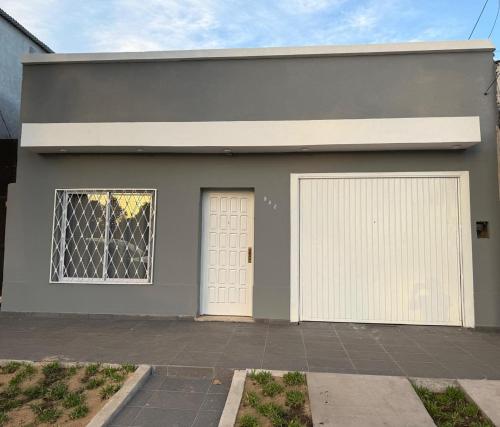ein graues Haus mit zwei Garagentoren und einem Fenster in der Unterkunft Alojamiento Yvoty in Paso de los Libres